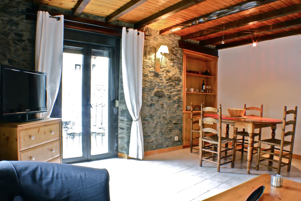 Living room area with wood ceiling and stone walls