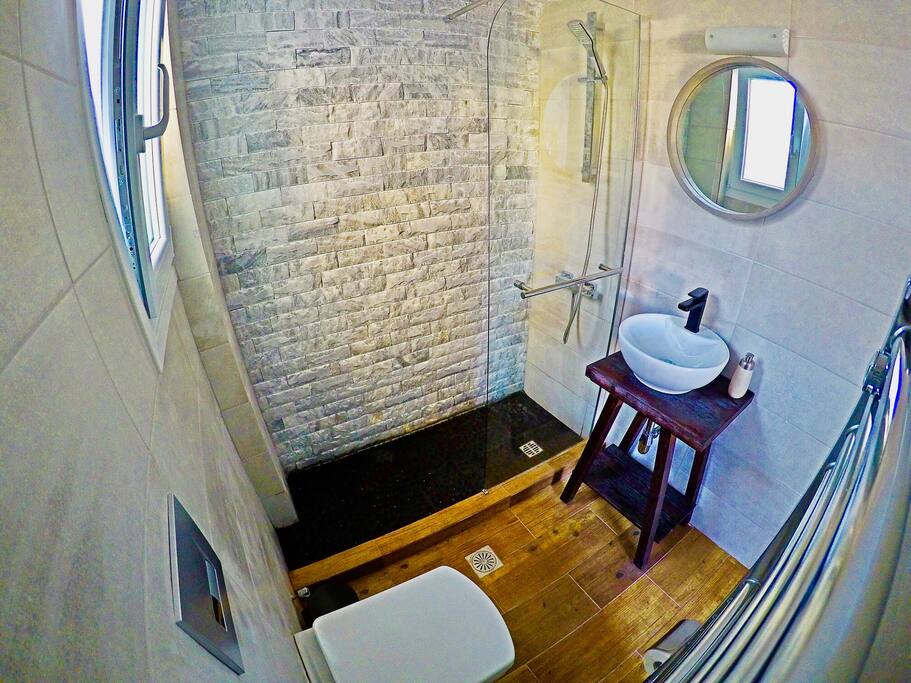 Enjoy a revitalizing shower in the aesthetic bathroom. The main elements here are wood and stones.