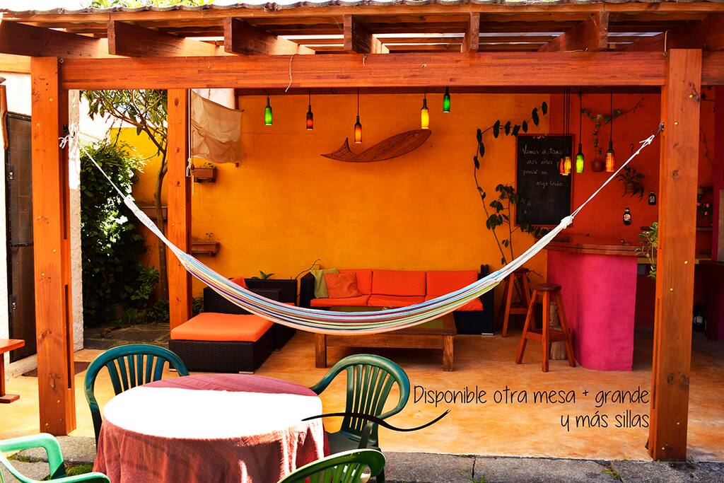 Parrillero exterior techado, con juego de living, bar, mesadas y pileta.