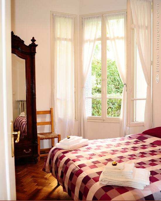 second bedroom with huge windows and view to the calm palm tree garden