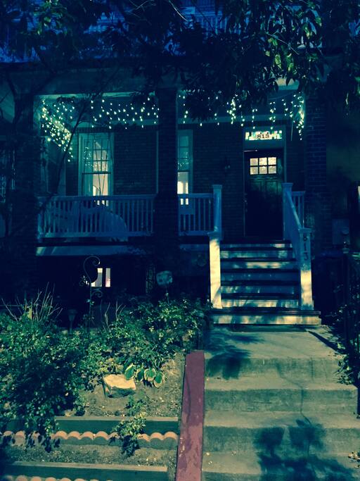 Evening view with twinkle lights and front porch swing.