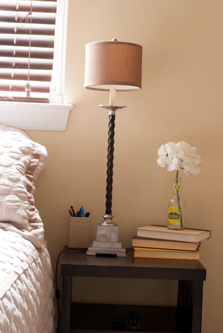 This room is simply decorated with calming tones of white and brown. Natural light fills the room by day and the warm glow of the lamp by night. The dark blinds help keep the street lights out for a restful and undisturbed sleep.
