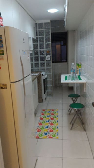 Cozinha com fogão , microonda , freezer , cafeteira , geladeira , área de serviço com máquina de lavar roupa , tanque e banheiro