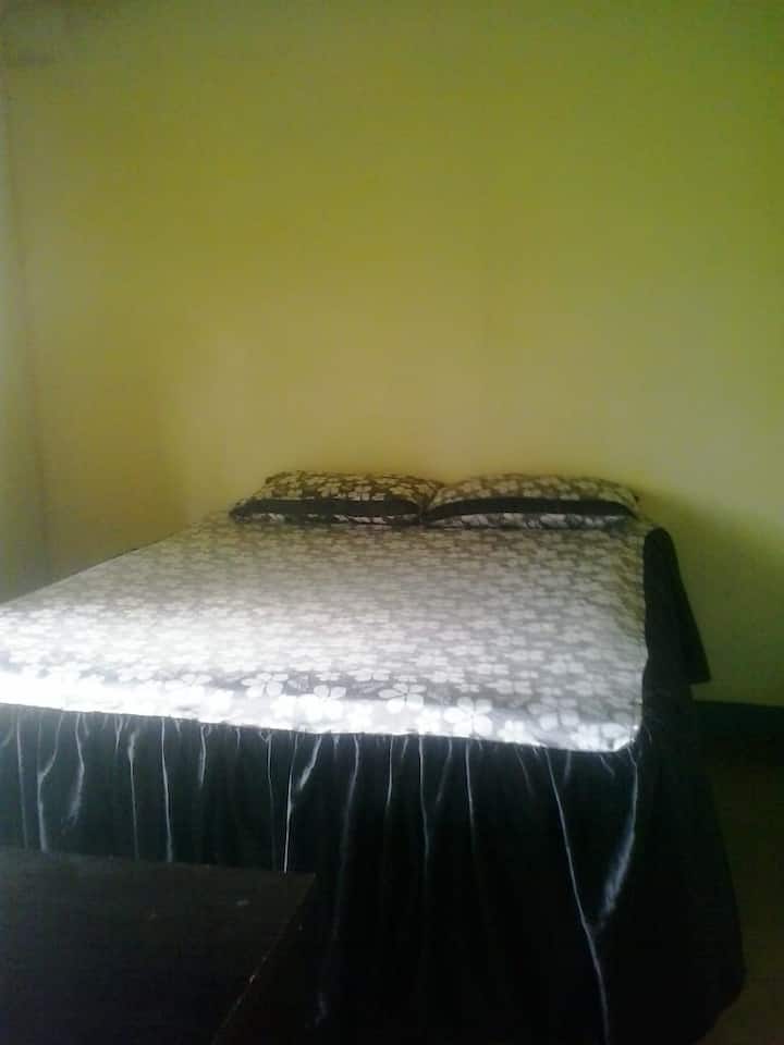 një dhomë gjumi me krevat dopio dhe mbulesë krevati tek të disponueshme