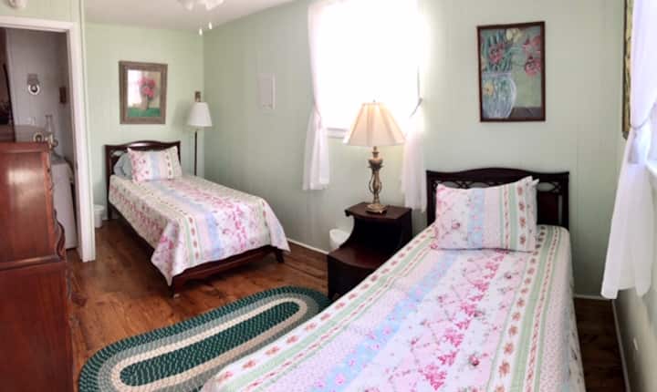 בחדר של ורד שרון יש שתי מיטות נפרדות ויצירות אמנות מקוריות על הקירות.
