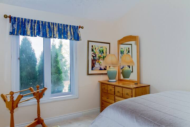 Chumba cha kulala cha tatu kwenye sakafu kuu kina kitanda na kabati la nguo.  