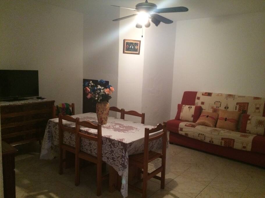 Salle à manger avec télé et canapé lit.