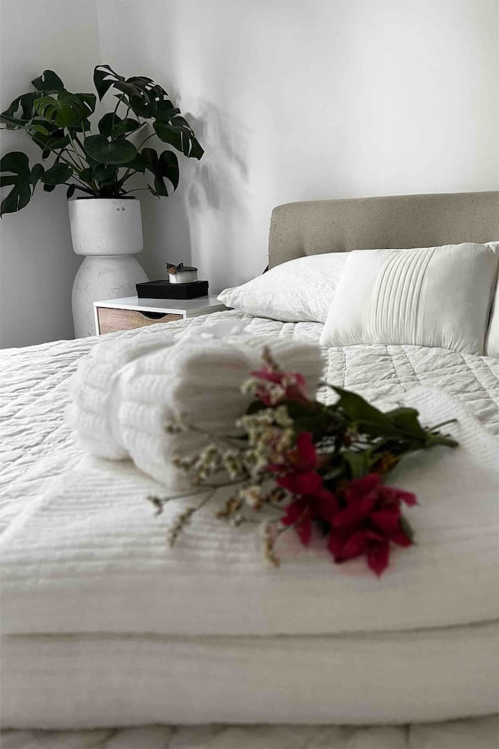 חדר שינה שני - מיטת קינג סייז עם חלון גדול הפונה לחלק האחורי של הבית עצים גבוהים. 