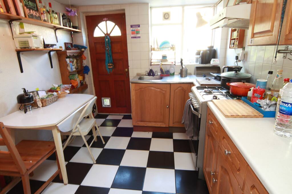 Kitchen equipped with necessary utensils with back door leading to the garden.
