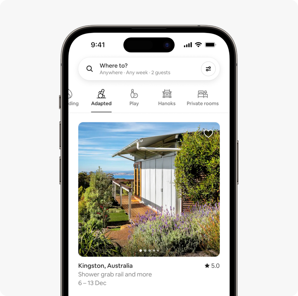 A laptop and a phone show the Airbnb homepage with two rows of homes from a new Airbnb November Release category called Adapted, which features wheelchair-accessible homes that have confirmed step-free access to the bedrooms and bathrooms.