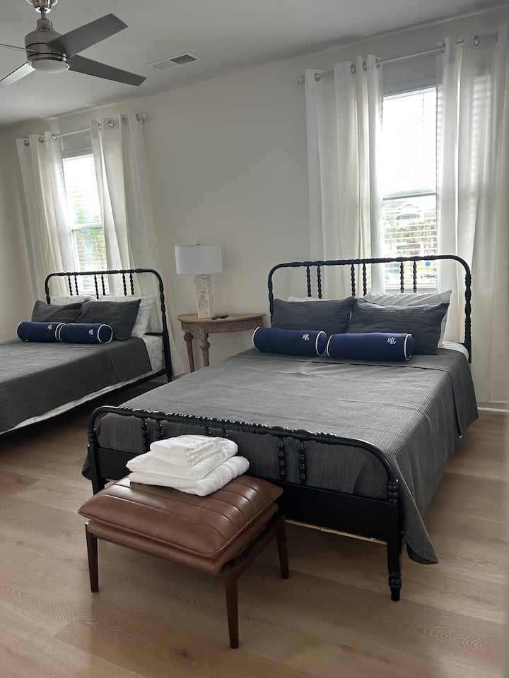 主卧舒适，配有两张标准双人床、自然光、配有双大梳妆台和衣柜的套房浴室，以及两个宽敞的步入式衣柜，配有大型平板电视。 