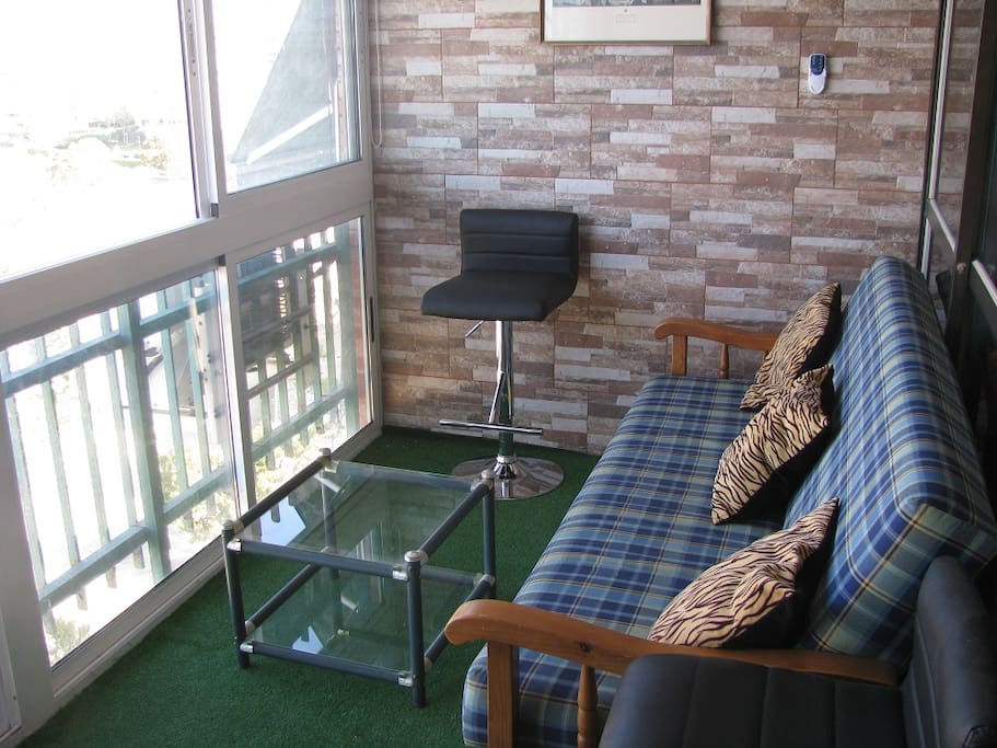 Terraza acristalada con sofá cama