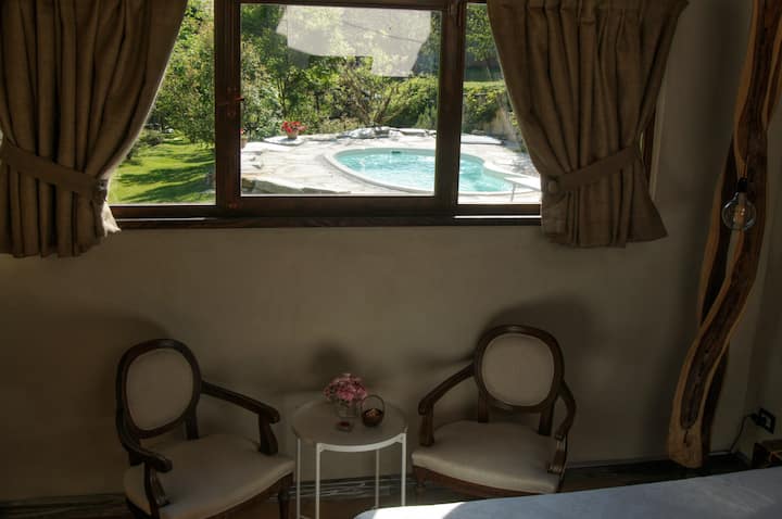 The view of the garden and private pool from the bedroom of Casetta nel Bosco.
