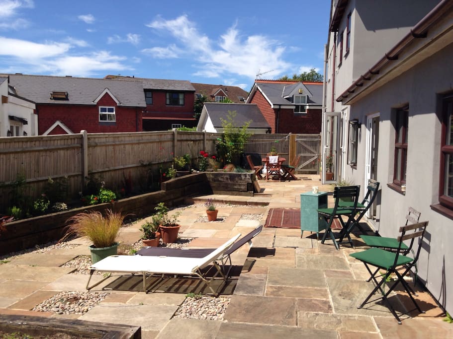 South facing, with beautiful flowers, outdoor seating and loungers.