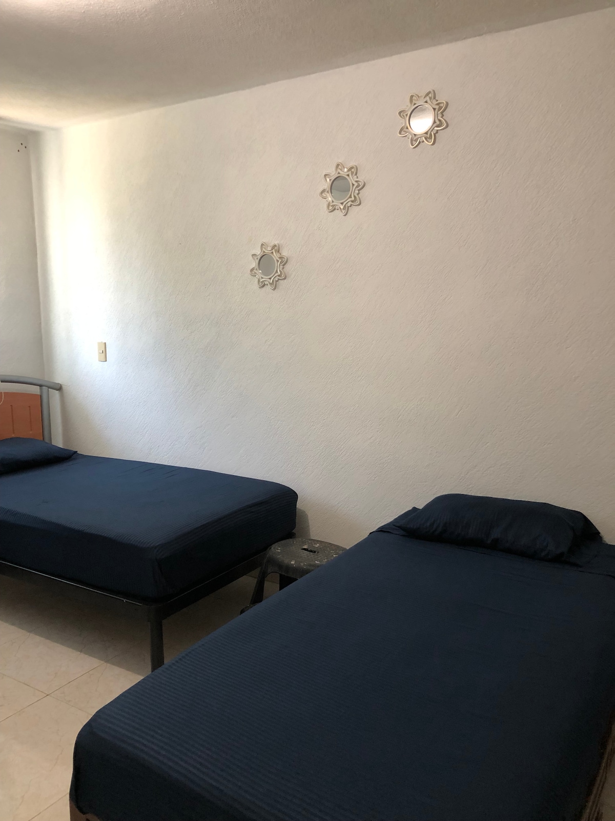 The master bedroom has three single beds with air conditioning and a private bathroom.