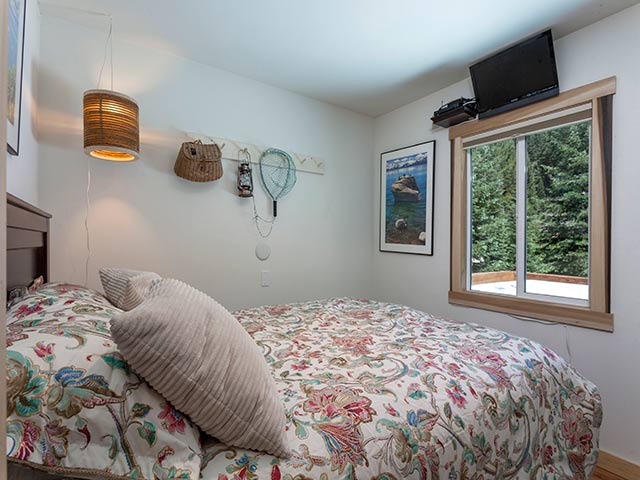 Menšia manželská posteľ s výhľadom na rieku.