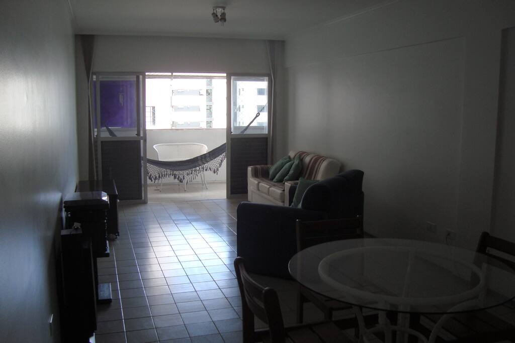 Sala estar/jantar; ao fundo, varandão.