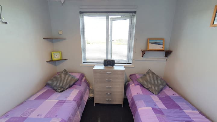 Spálňa s dvoma oddelenými posteľami má výhľad na zadné pole na východ.