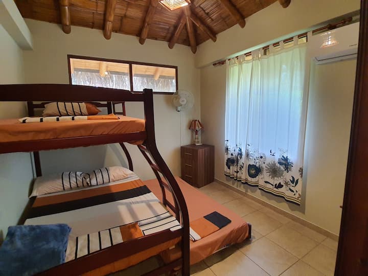 Dormitorio 1 donde descansarás, cuenta con 1 trilera; que tiene una cama en la parte superior y otra en la parte inferior que sale con ruedas; ambas de plaza y media, y una cama de 2 plazas en la mitad. 