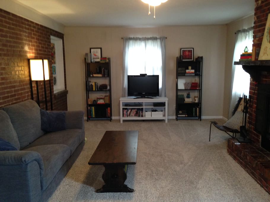 Spacious family room with TV, couch, and 3 reading chairs.
