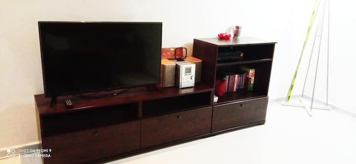 غرفة مع تلفزيون ذكي وواي فاي وأريكة ومحطة عمل مع مكتب 