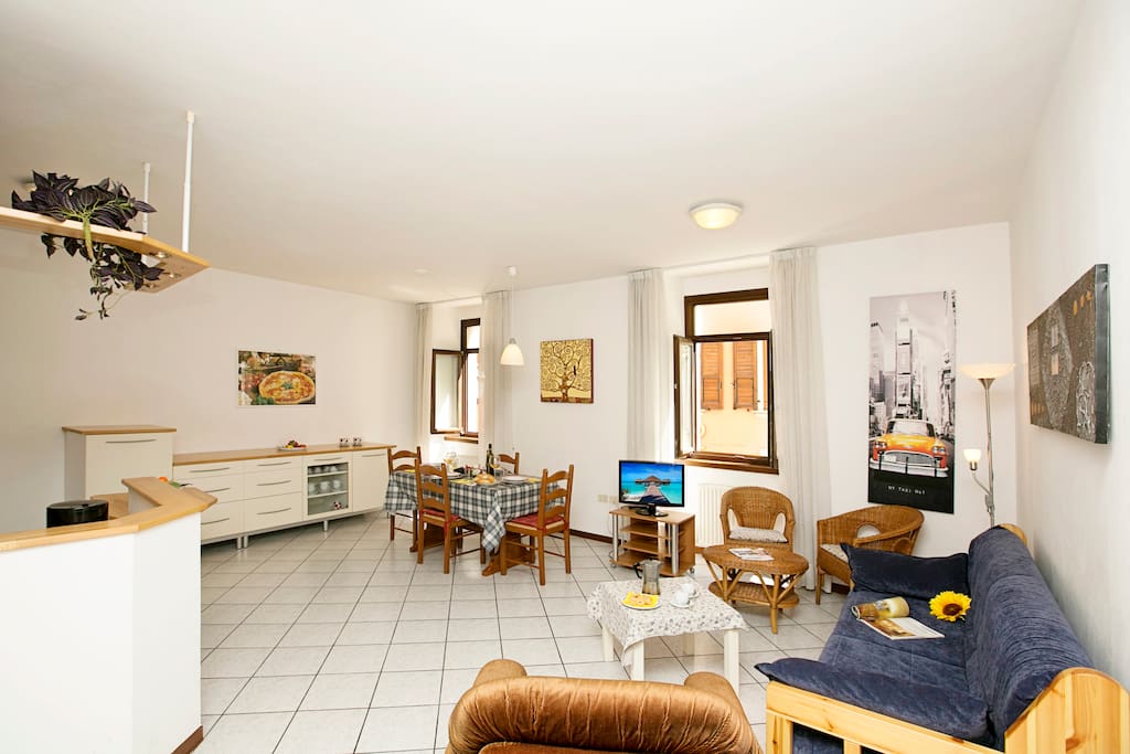 The livingroom with dinner table, sofa and wicker chairs
