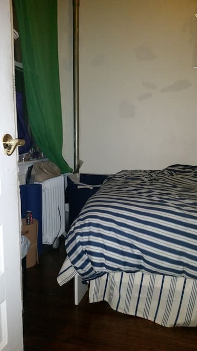 Bedroom with additional space heater, and tall window.
