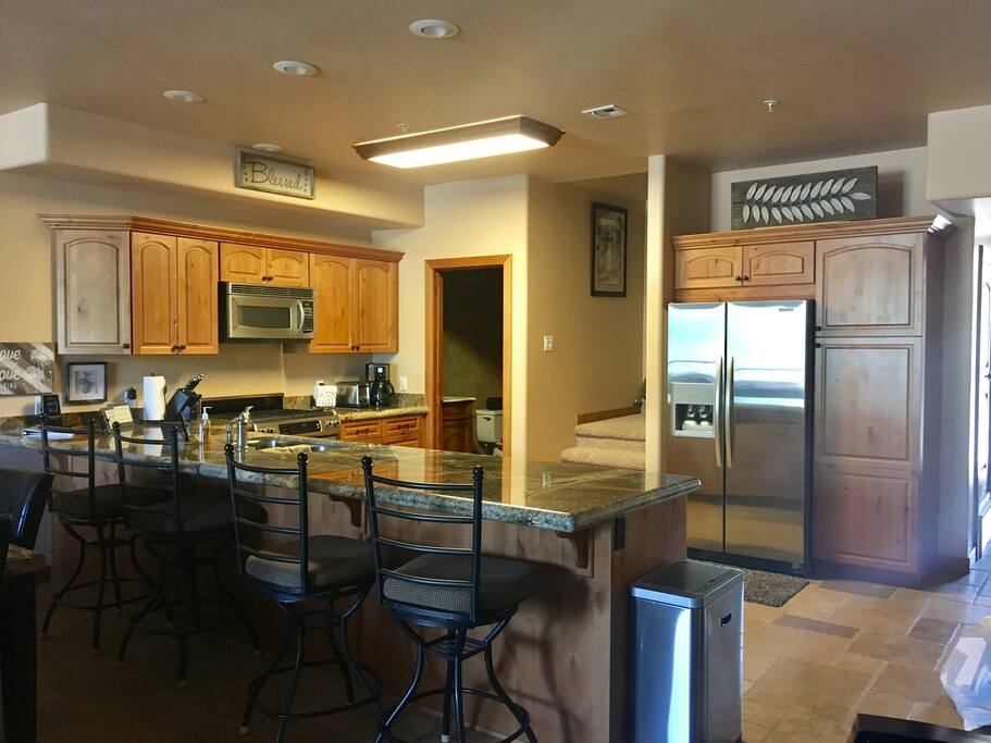 Comfortable bar stools in kitchen, downstairs half-bath next to stairs