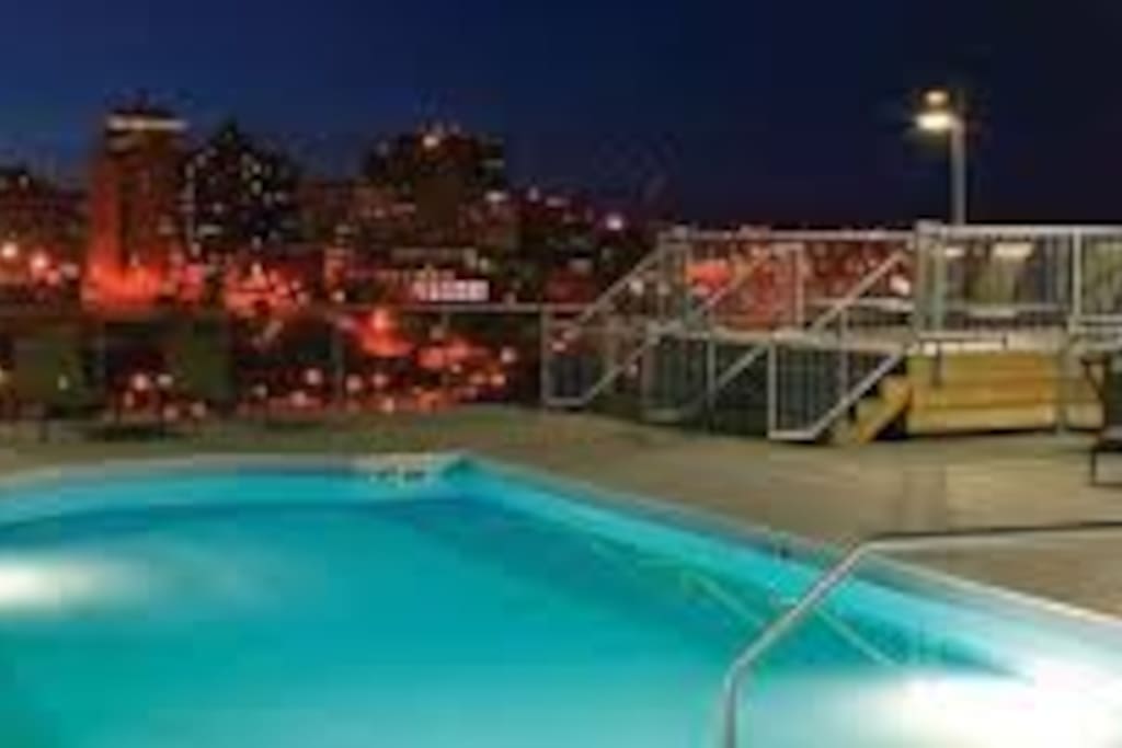 Rooftop pool at night overlooking the city.