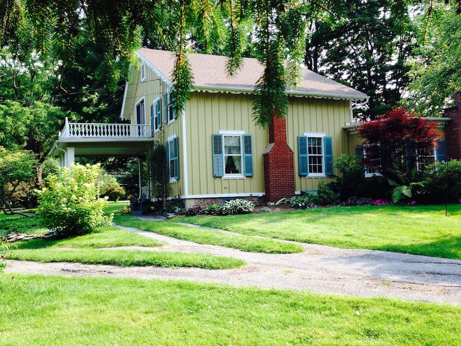 Quaint English cottage with historic board and batten siding. Covered porte cochere makes loading and unloading the car nice and easy . . . and dry, if it's raining out.