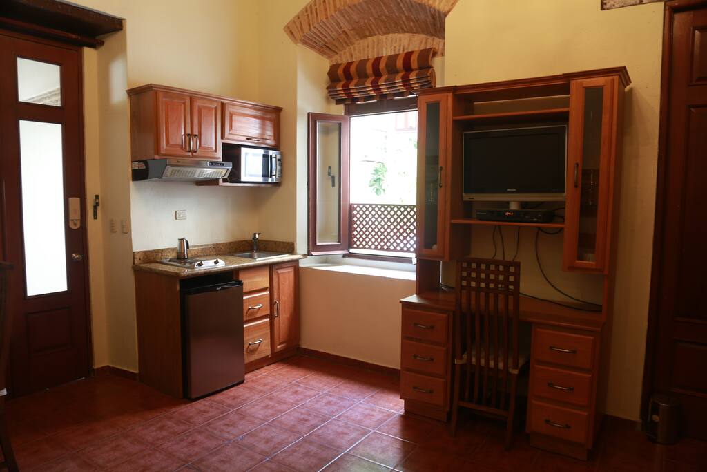 Desk with TV on top. Kitchen on the left