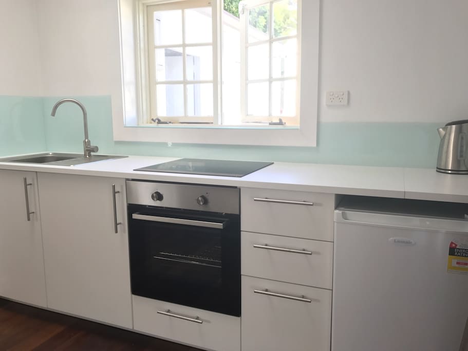 Brand new kitchenette with oven, cooktop, bar fridge and kettle.