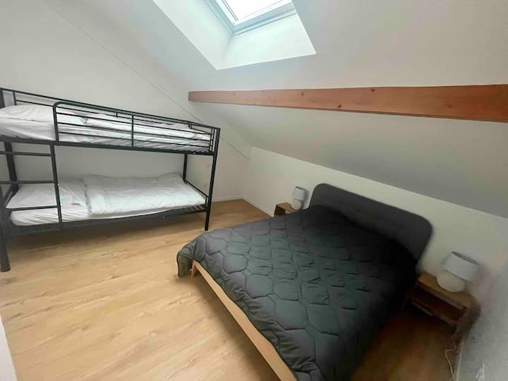 Habitación con cama doble y literas. 