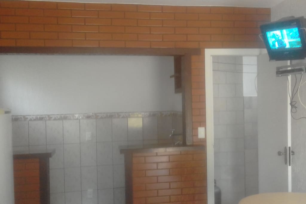 frente da cozinha americana, com tv.