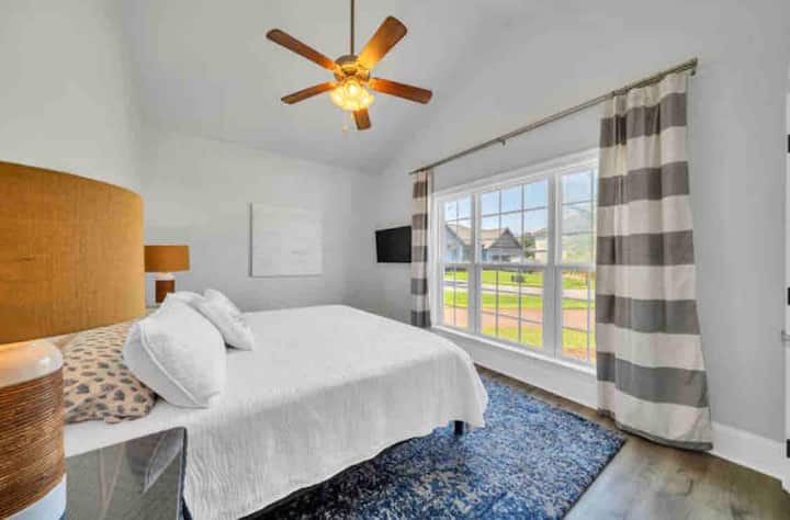 חדר שינה קינג, נוף מדלת חדר השינה המציג חלון תמונה מואר, תקרות קמורות וטלוויזיה תלוית קיר. 