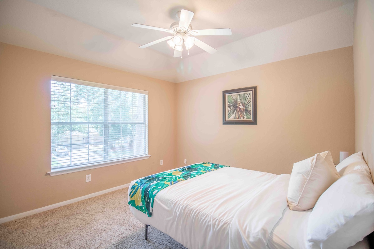 Spavaća soba 4 s krevetom pune veličine i pogledom na ulicu s drvoredima i dvorište