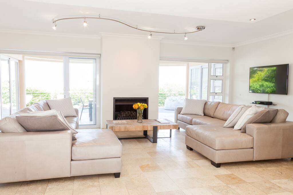 Shared lounge with comfortable leather sofa's, a gas fire place and doors leading out on to the private patio with pool and built in gas bbq