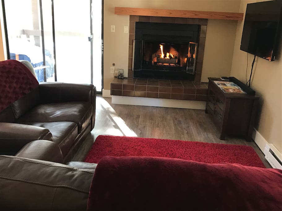 Spacious, bright living area with leather sofa and love seat.