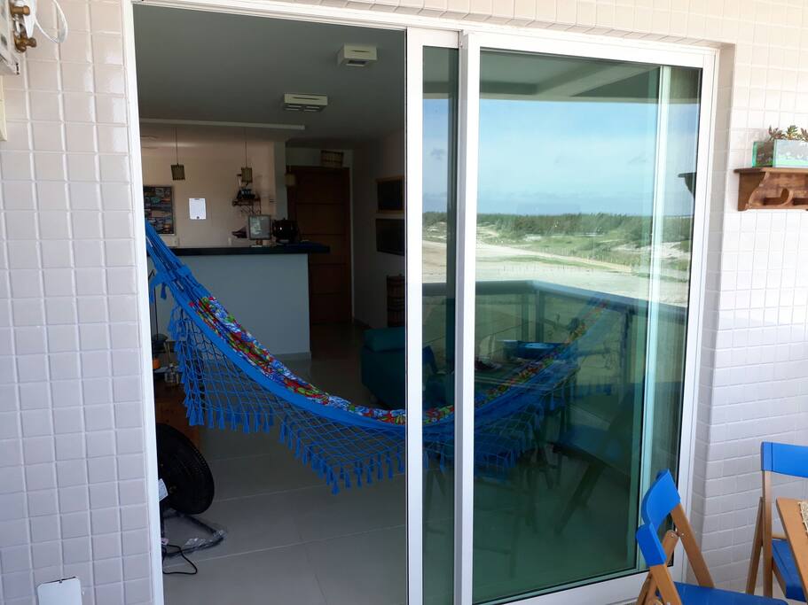Sala, varanda e uma boa rede para descanso.