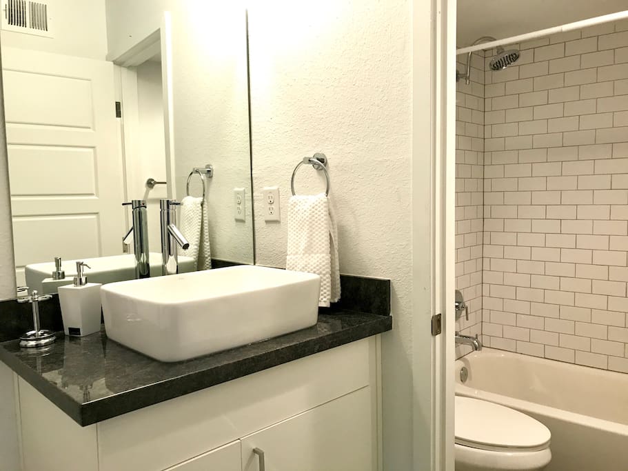 Brand new bathroom with custom vanity, subway tiles, luxury shower head.