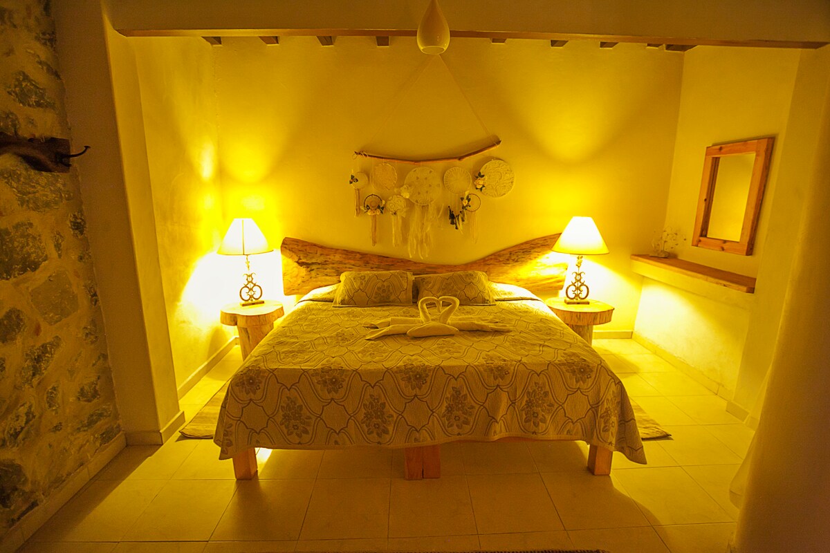 Recamara con cama queen size y ropa de cama