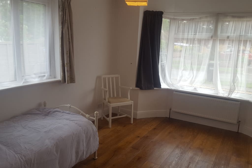 Two large windows with net curtains for privacy.