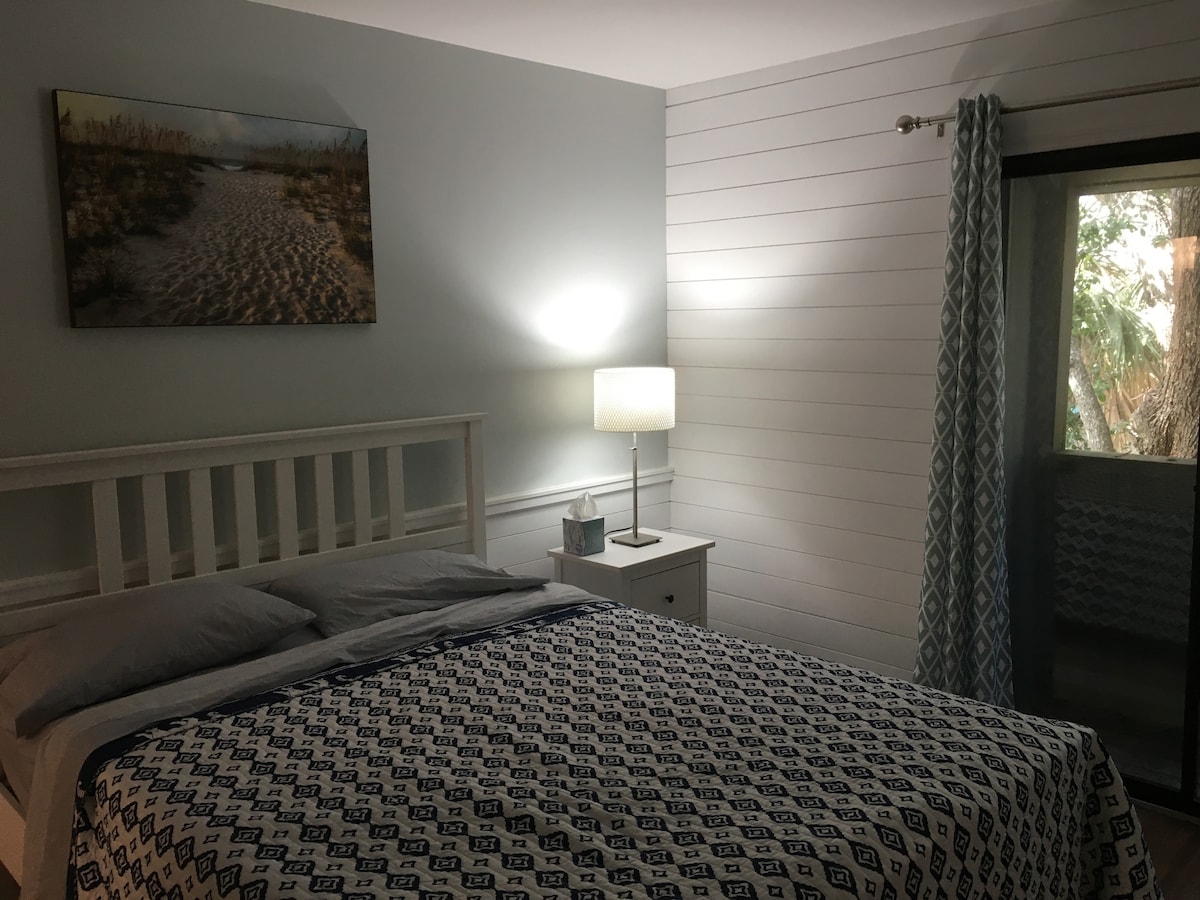 غرفة نوم رئيسية مع طاولات جانبية مع أدراج 