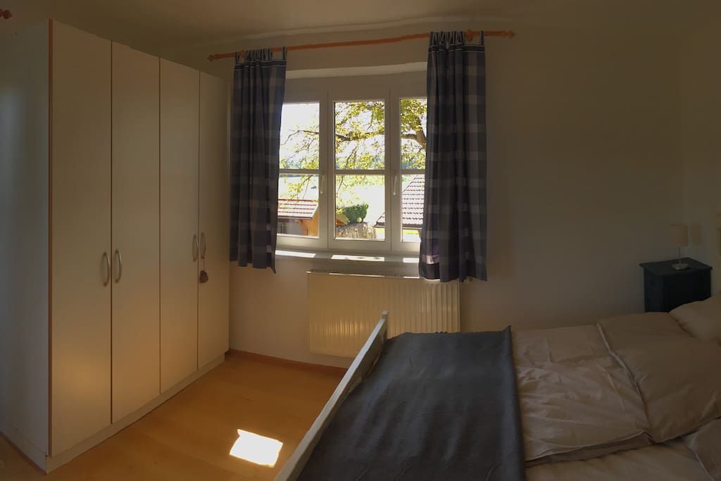 Bedroom with queen size bed (with a very comfy mattress) and view towards the walnut trees and forest