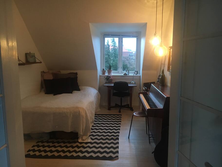 Dette er soveværelset. Det er ca 12 m2, med en skøn udsigt over Frederiksberg. Der er franske døre imellem værelse og stue. Der kan trækkes et gardin for, så man har fuldstændig privatliv.