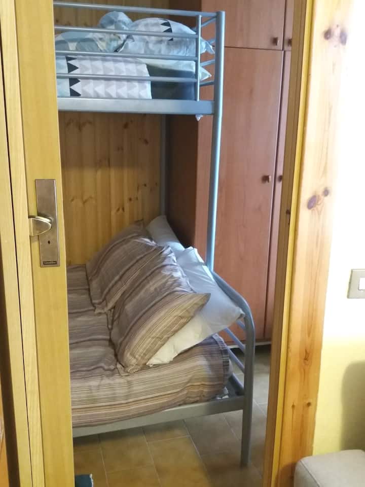 Mwonekano wa chumba cha kulala kilicho na kitanda cha ghorofa, cha watu wawili na cha mtu mmoja.