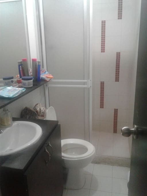 Baño, lavamanos, ducha con calentador eléctrico.