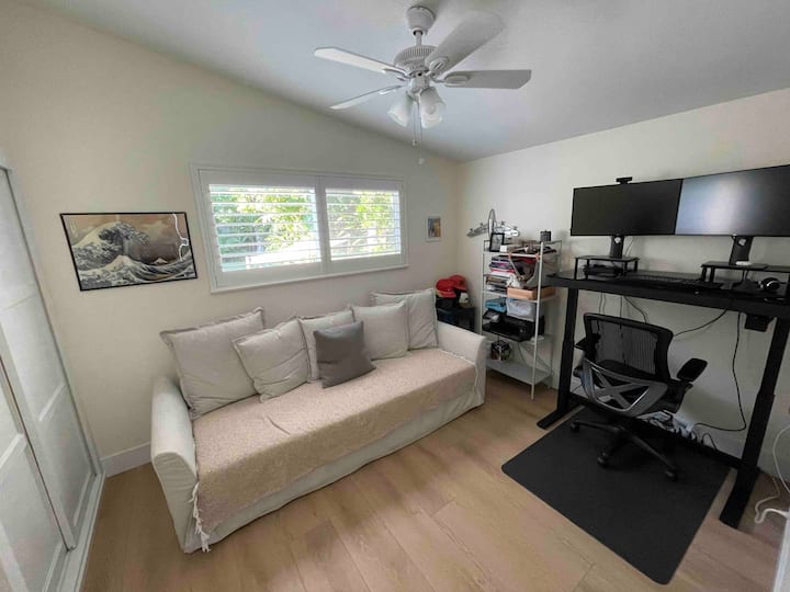 Dormitorio con sofá cama y mesa de estar/mesa de estar electrónica