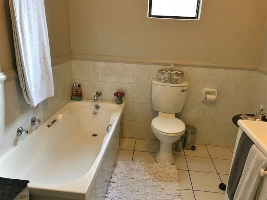 The bathroom has a bath and shower
