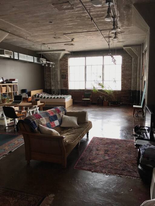 Cozy, open layout studio with warm natural lighting.